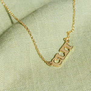 Clit Silver Necklace Gold Plated Made in Italy. Green fabric background.
